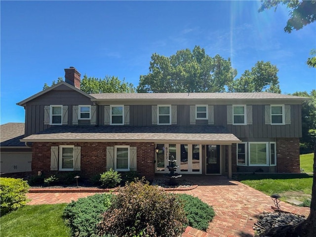 6317 Sherwood Ln, Shawnee, KS 66203 - view of front facade featuring a chimney, brick siding, board and batten siding, french doors, and a shingled roof