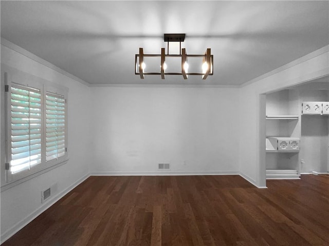 6317 Sherwood Ln, Shawnee, KS 66203 - unfurnished dining area featuring a chandelier, crown molding, dark wood finished floors, built in features, and baseboards