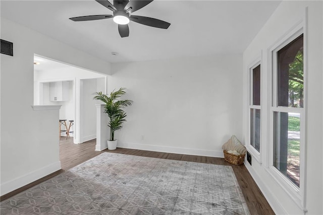 8823 E 111th St, Kansas City, MO 64134 - spare room featuring wood finished floors, a ceiling fan, and baseboards