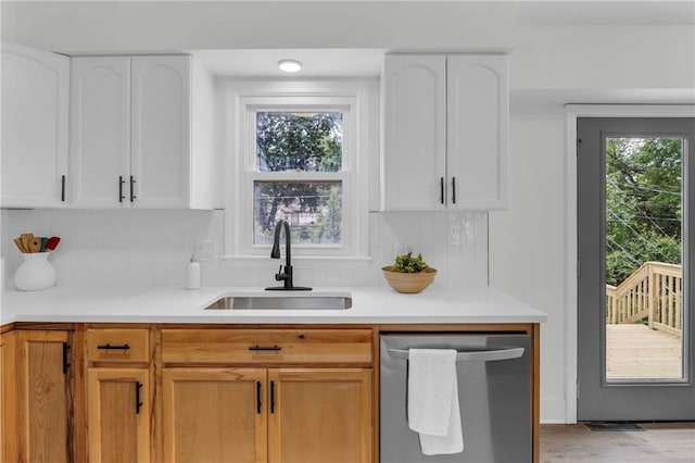 8823 E 111th St, Kansas City, MO 64134 - kitchen with dishwasher, a sink, backsplash, and light countertops
