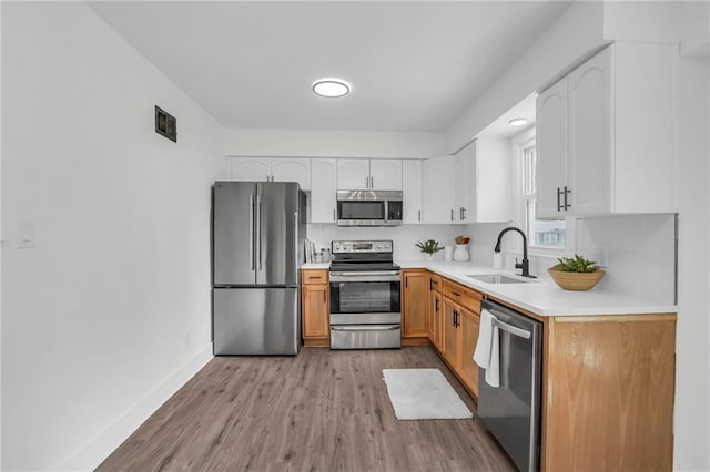 8823 E 111th St, Kansas City, MO 64134 - kitchen featuring appliances with stainless steel finishes, a sink, backsplash, white cabinets, and light countertops