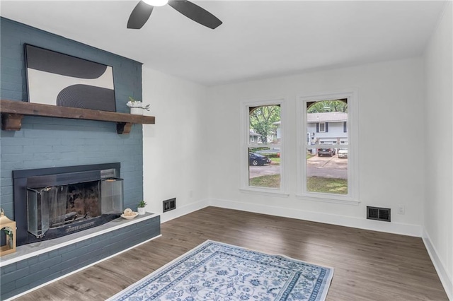 8823 E 111th St, Kansas City, MO 64134 - unfurnished living room featuring ceiling fan, baseboards, a fireplace, and wood finished floors