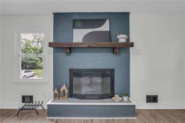 8823 E 111th St, Kansas City, MO 64134 - detailed view of wood finished floors, baseboards, and a fireplace