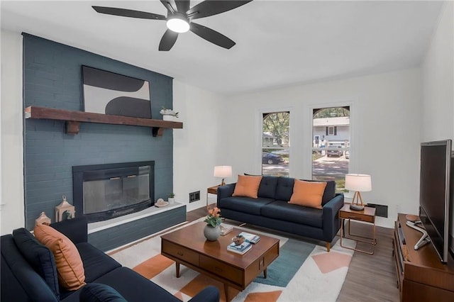 8823 E 111th St, Kansas City, MO 64134 - living area featuring wood finished floors, a large fireplace, and a ceiling fan