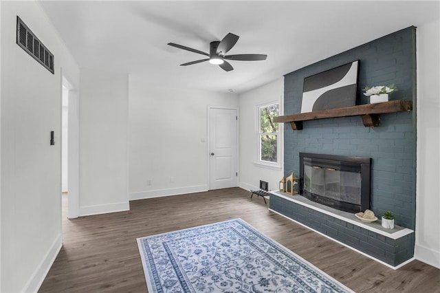 8823 E 111th St, Kansas City, MO 64134 - unfurnished living room featuring baseboards, wood finished floors, ceiling fan, and a fireplace