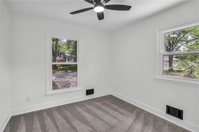 8823 E 111th St, Kansas City, MO 64134 - empty room with healthy amount of natural light, dark carpet, and baseboards