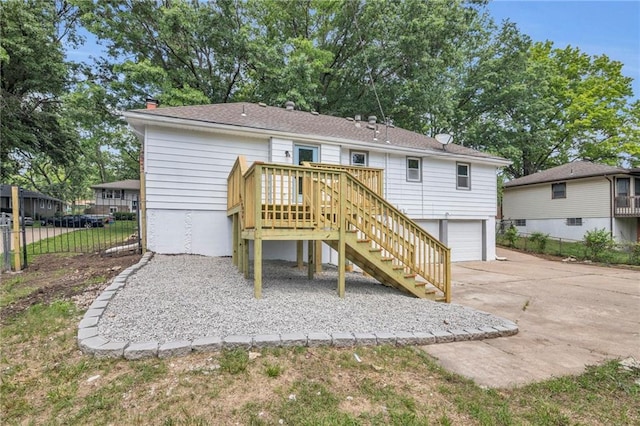 8823 E 111th St, Kansas City, MO 64134 - back of property with concrete driveway, an attached garage, stairway, and a chimney
