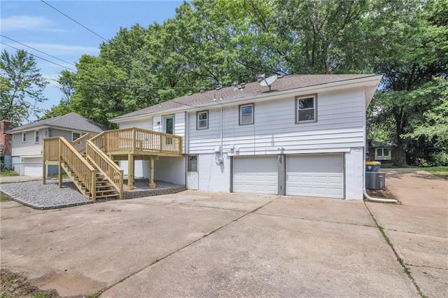 8823 E 111th St, Kansas City, MO 64134 - back of property with a garage, driveway, a deck, and stairway