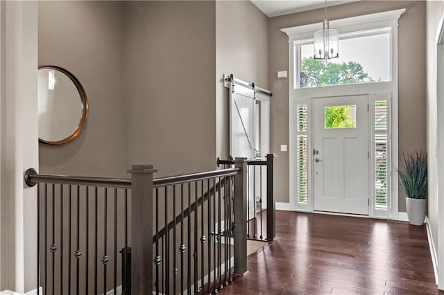 8756 Houston St, Lenexa, KS 66227 - foyer entrance with wood finished floors, a towering ceiling, a barn door, and a chandelier