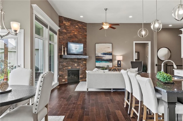 8756 Houston St, Lenexa, KS 66227 - dining room with a ceiling fan, dark wood-style flooring, a stone fireplace, and recessed lighting