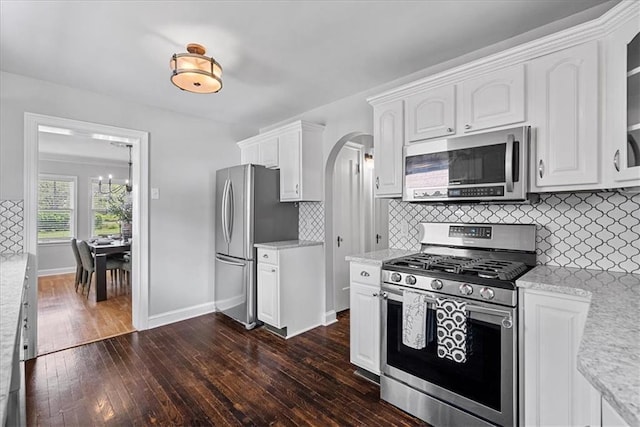 7224 Ward Pkwy, Kansas City, MO 64114 - kitchen featuring appliances with stainless steel finishes, dark wood-style floors, white cabinets, decorative backsplash, and baseboards