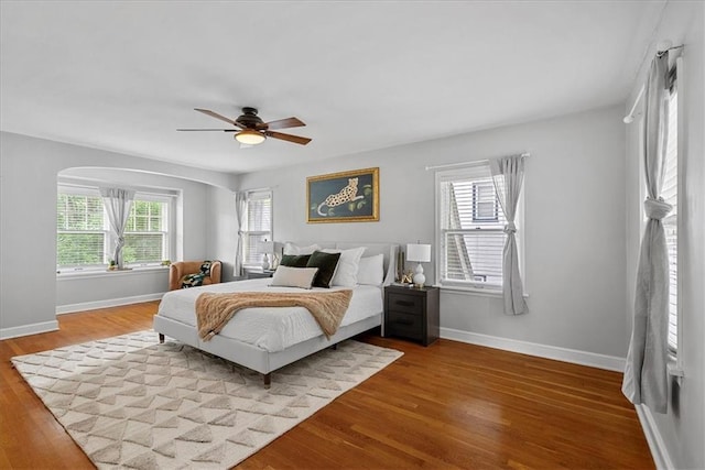 7224 Ward Pkwy, Kansas City, MO 64114 - bedroom featuring baseboards, wood finished floors, ceiling fan, and arched walkways
