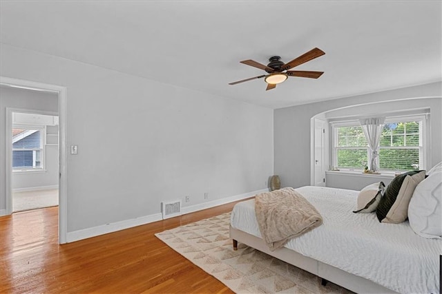 7224 Ward Pkwy, Kansas City, MO 64114 - bedroom with wood finished floors, baseboards, a ceiling fan, and arched walkways