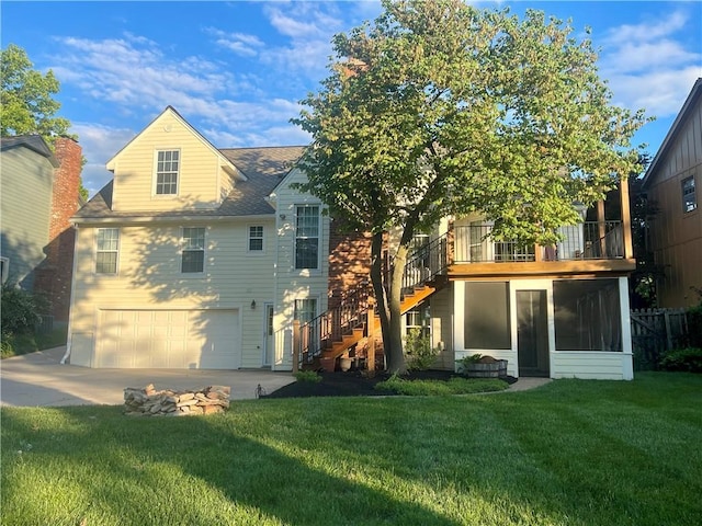 8122 Parkhill Rd, Lenexa, KS 66215 - back of property with stairs, a garage, a lawn, driveway, and a sunroom