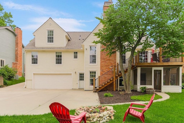 8122 Parkhill Rd, Lenexa, KS 66215 - rear view of property featuring an attached garage, a sunroom, stairs, driveway, and a shingled roof