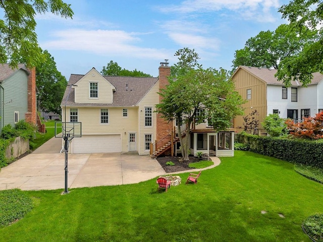 8122 Parkhill Rd, Lenexa, KS 66215 - rear view of house featuring a sunroom, an attached garage, concrete driveway, stairway, and a yard