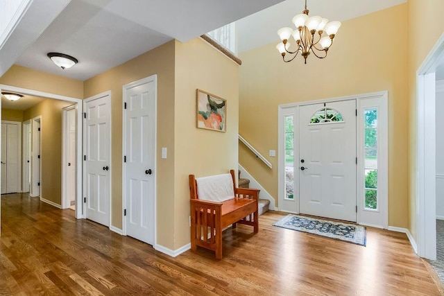 8122 Parkhill Rd, Lenexa, KS 66215 - foyer entrance featuring wood finished floors, a chandelier, stairway, baseboards, and a towering ceiling