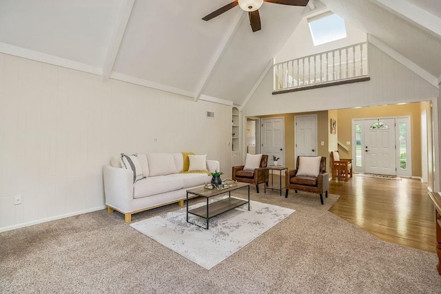 8122 Parkhill Rd, Lenexa, KS 66215 - carpeted living area with beam ceiling, a ceiling fan, high vaulted ceiling, wood finished floors, and wood walls