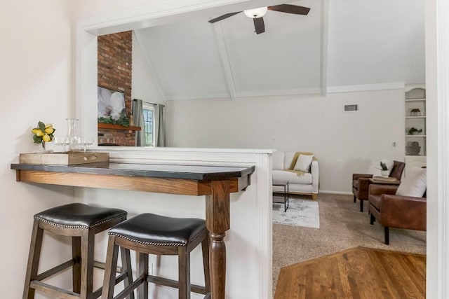 8122 Parkhill Rd, Lenexa, KS 66215 - kitchen with carpet floors, a ceiling fan, a kitchen bar, and open floor plan