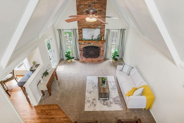 8122 Parkhill Rd, Lenexa, KS 66215 - carpeted living room with ceiling fan, beamed ceiling, a brick fireplace, and high vaulted ceiling