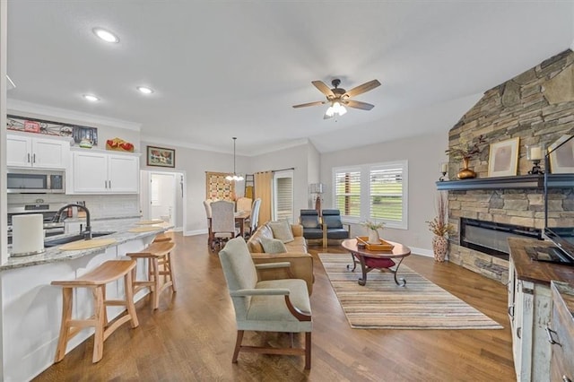 4500 Valley Ridge Dr, Saint Joseph, MO 64505 - living area with baseboards, a fireplace, a ceiling fan, wood finished floors, and crown molding