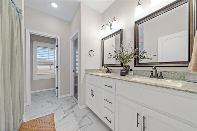 4500 Valley Ridge Dr, Saint Joseph, MO 64505 - bathroom with marble look tiles, baseboards, and double vanity