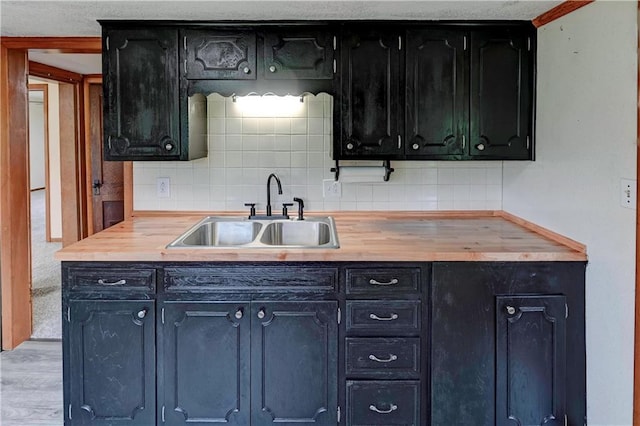 10855 72nd Rd, Agency, MO 64401 - kitchen featuring a sink, tasteful backsplash, wooden counters, and dark cabinetry