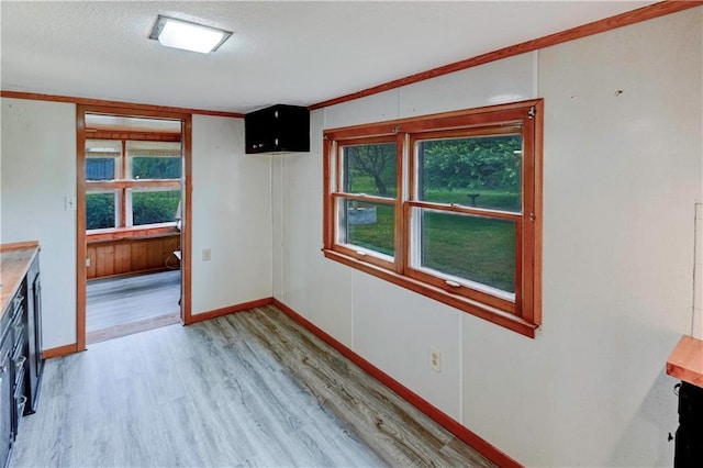 10855 72nd Rd, Agency, MO 64401 - unfurnished dining area featuring light wood-style flooring, baseboards, a textured ceiling, and crown molding