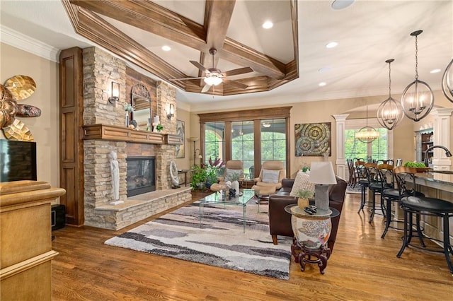 3116 W 137th St, Leawood, KS 66224 - living room featuring a fireplace, a chandelier, a ceiling fan, wood finished floors, and crown molding