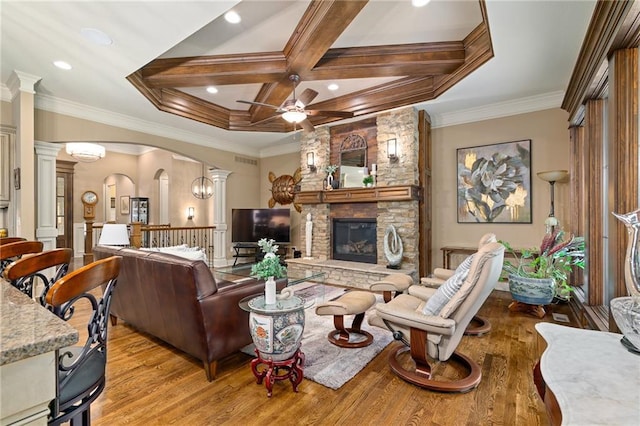 3116 W 137th St, Leawood, KS 66224 - living room with decorative columns, light wood-style flooring, a fireplace, arched walkways, and coffered ceiling