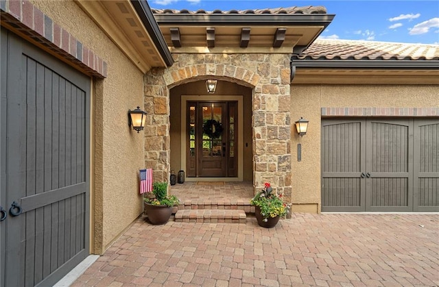 3116 W 137th St, Leawood, KS 66224 - doorway to property featuring a tile roof, stone siding, an attached garage, and stucco siding