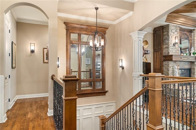 3116 W 137th St, Leawood, KS 66224 - corridor with an upstairs landing, a chandelier, wood finished floors, crown molding, and arched walkways
