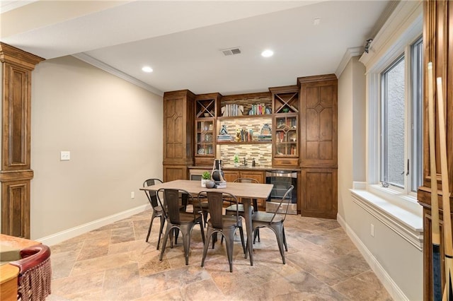 3116 W 137th St, Leawood, KS 66224 - dining area featuring beverage cooler, light stone finish floors, ornamental molding, baseboards, and recessed lighting