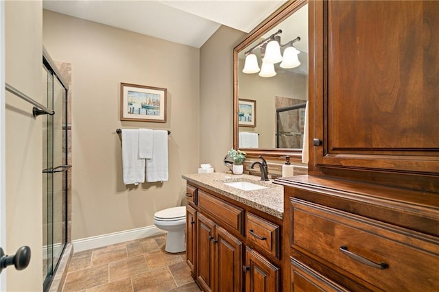 3116 W 137th St, Leawood, KS 66224 - bathroom featuring baseboards, a shower with shower door, vanity, toilet, and stone finish floors