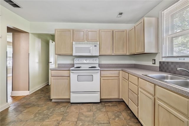 906 W 84th St, Kansas City, MO 64114 - kitchen featuring white appliances, light brown cabinetry, a sink, stone finish flooring, and baseboards