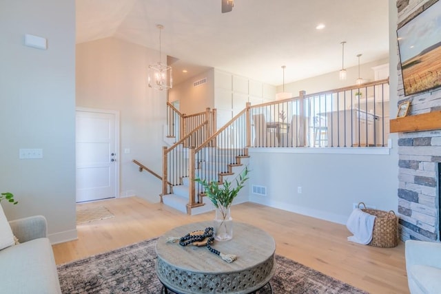 16721 Pinehurst Dr, Basehor, KS 66007 - living area featuring wood finished floors, a chandelier, high vaulted ceiling, baseboards, and stairway