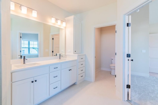 16721 Pinehurst Dr, Basehor, KS 66007 - bathroom featuring toilet, double vanity, and baseboards