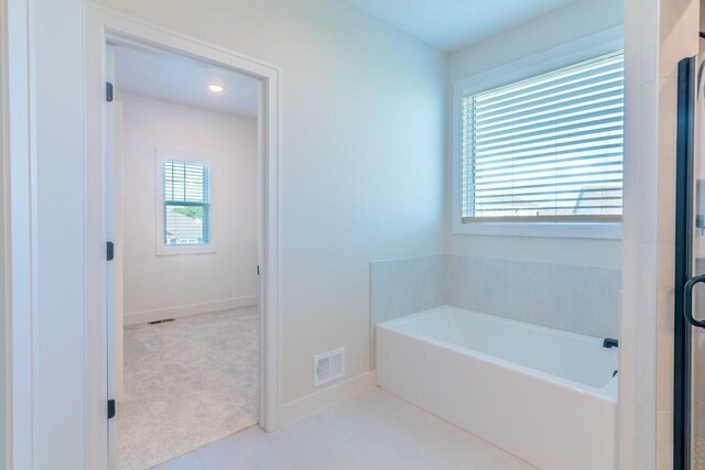 16721 Pinehurst Dr, Basehor, KS 66007 - bathroom featuring a garden tub and baseboards