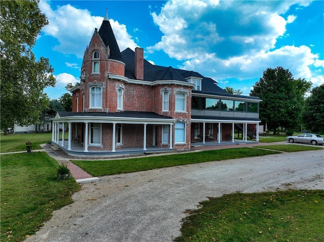 433 W State St, Troy, KS 66087 - view of front of house featuring a porch, brick siding, a front lawn, and a chimney