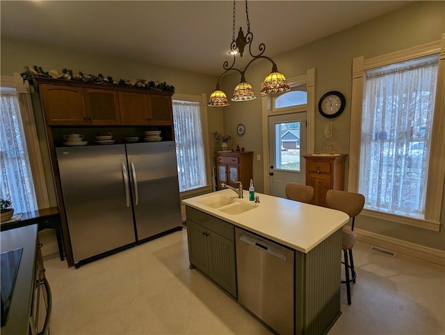 433 W State St, Troy, KS 66087 - kitchen with stainless steel appliances, a sink, light carpet, decorative light fixtures, and a breakfast bar area