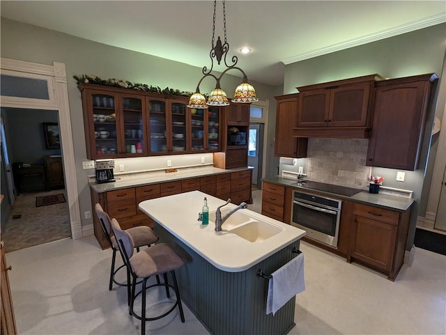 433 W State St, Troy, KS 66087 - kitchen with black appliances, a sink, a kitchen island with sink, glass insert cabinets, and tasteful backsplash