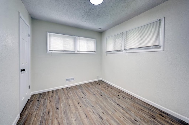 10711 Bennington Ave, Kansas City, MO 64134 - unfurnished room with a textured ceiling, wood finished floors, and baseboards