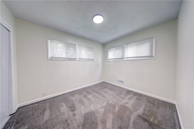 10711 Bennington Ave, Kansas City, MO 64134 - unfurnished bedroom with carpet flooring, a textured ceiling, baseboards, and a closet