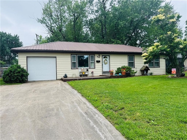 310 E Monroe Ave, Garnett, KS 66032 - ranch-style home featuring a front lawn, driveway, metal roof, and a garage