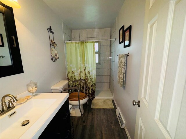 310 E Monroe Ave, Garnett, KS 66032 - full bathroom with toilet, vanity, a tile shower, and wood finished floors