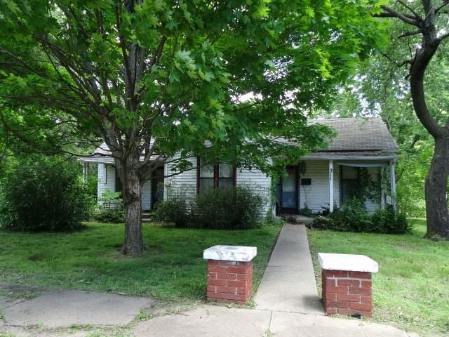 309-311 N Lyon St, Butler, MO 64730 - obstructed view of property with a front yard