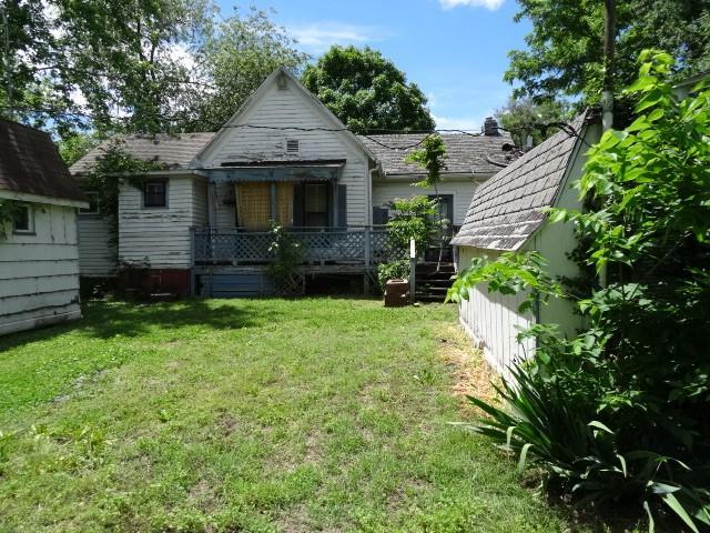 309-311 N Lyon St, Butler, MO 64730 - rear view of house featuring a lawn and a wooden deck