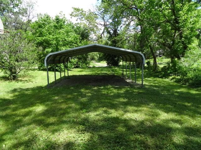309-311 N Lyon St, Butler, MO 64730 - view of home's community with a carport and a lawn