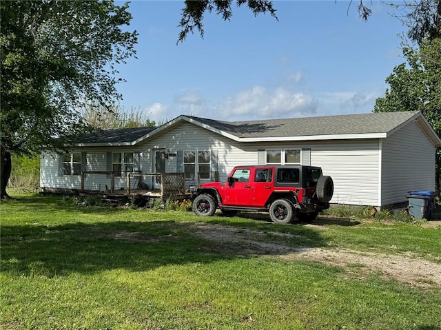 476 170th St, Fort Scott, KS 66701 - view of front of house with a front yard, a shingled roof, and a wooden deck