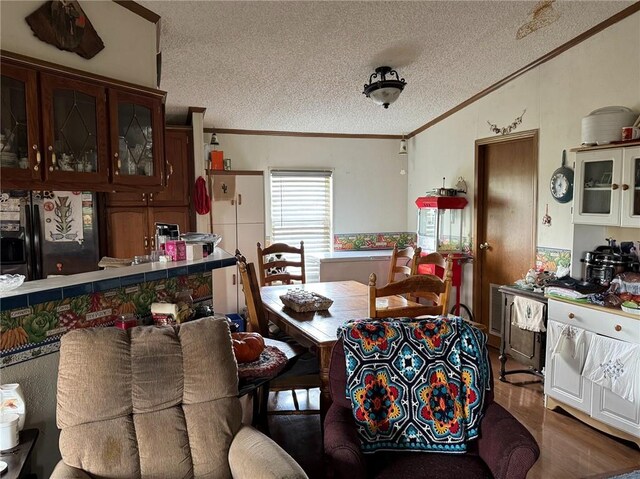 476 170th St, Fort Scott, KS 66701 - dining space featuring ornamental molding, a textured ceiling, and wood finished floors